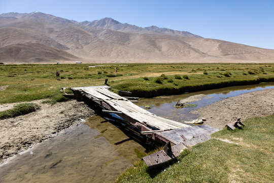 Aged bridge over a small river in Bulunkul in the Pamir mountains in Tajikistan