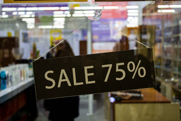 A sign with an inscription on the glass door of the store