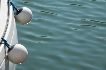 Two mooring buoys on the side of a boat. Water in the background and copy space for your text message or promotional content.