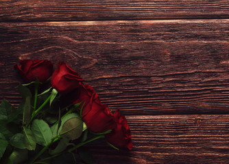 Fresh red roses on wooden desk. Flat lay. Copy space. Top view