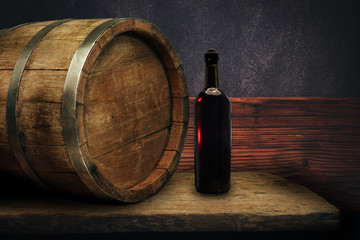 Red wine bottle on a old oak wooden table background barrel.