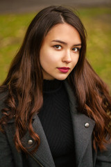 Naklejka premium Portrait of a young beautiful woman in gray coat
