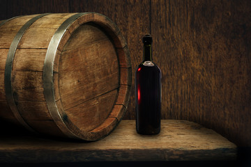 Red wine bottle on a old oak wooden table background barrel.