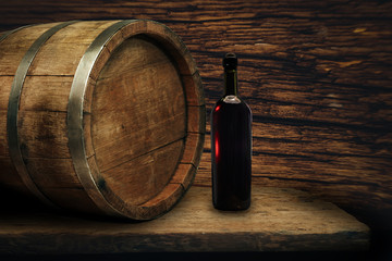 Red wine bottle on a old oak wooden table background barrel.