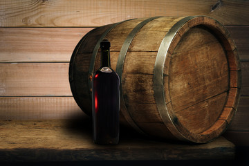 Red wine bottle on a old oak wooden table background barrel.