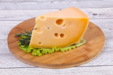 Maasdam cheese  in the board served salad leaves