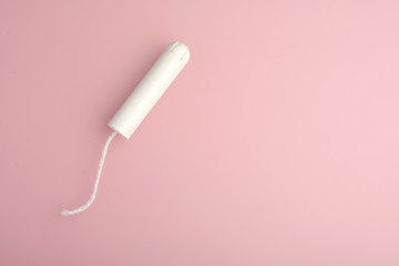 Tampon. Menstrual cycle, feminine care, menstruation and intimate products concept with internal tampon isolated on pink background with copy space .