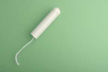 Tampon - flat lay. Menstrual tampon on a pink background. Menstruation time. Hygiene and protection. Pasterl colors. Copy space for text.