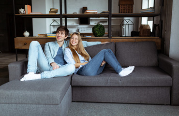 Fototapeta premium Full size portrait of attractive trendy couple sitting in modern open space apartment