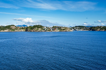 Fototapeta premium Kristiansund scenic landscape viewed from Hurtigruten cruise ship with colorful wooden houses along the coast, Norway.