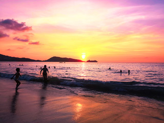 Fototapeta premium the sea at sunset and silhouettes of tourists