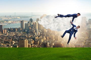 Businessman offering helping hand to falling colleague