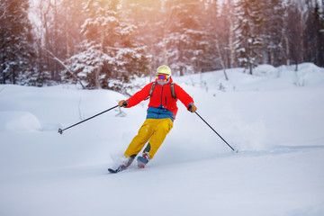 Young man in helmet and mask is skiing on sunny day