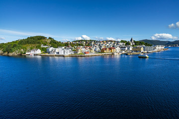 Fototapeta na wymiar Sunny cityscape of Kristiansund with a ferry boat approaching Nordlandet island, More og Romsdal, Norway