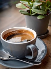 A large cup of fresh black coffee on a wooden bar in a coffee shop