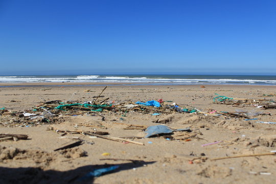 Polluted beach, carbon footprint, plastic on the sand