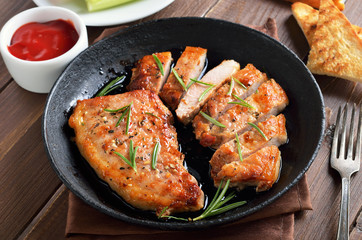 Baked pork steaks in frying pan, tomato sauce