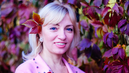 Fototapeta premium woman with a smile in a pink wool jumper with beads in spring or autumn with free space for inscriptions, signatures.