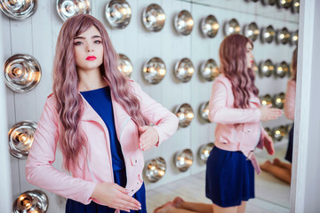 Fashion freak. Glamour synthetic girl, fake doll with empty look and long lilac hair is sitting in...