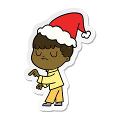 sticker cartoon of a grumpy boy wearing santa hat