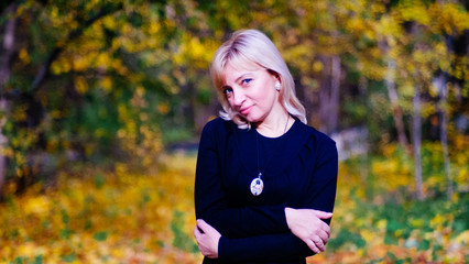 bright beautiful happy blonde woman with blue eyes in black dress on a walk in the Park.
