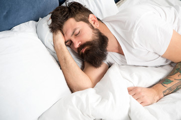 Fototapeta na wymiar Sleep disorders concept. Man bearded hipster having problems with sleep. Guy lying in bed try to relax and fall asleep. Relaxation techniques. Violations of sleep and wakefulness. Need some rest