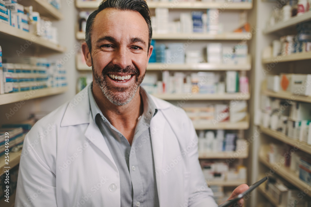 Wall mural Professional male pharmacist working in medical store