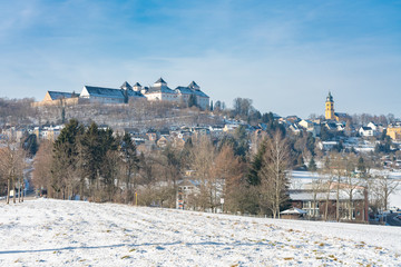 das Jagdschloss Augustusburg, im Winter bei weißem Schnee und blauem Himmel