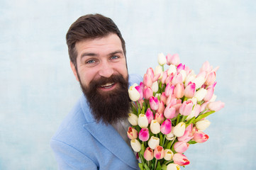 Spring holiday. Man bearded suit bow tie hold tulip flowers bouquet. Gentleman romantic surprise for her. Flowers delivery. Gentleman romantic date. Birthday greetings. Best flowers for girlfriend