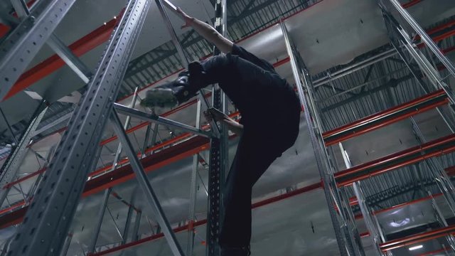 Climber without insurance on rollers in the logistics center