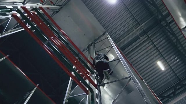Climber without insurance on rollers in the logistics center