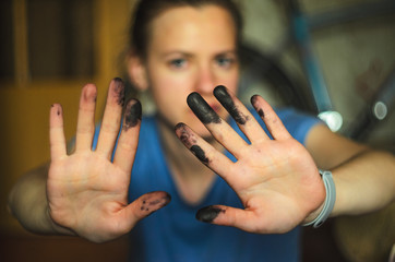 Woman shows hands soiled with black ink for printer