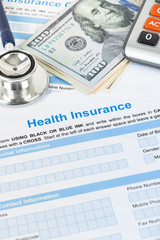 Health insurance application form with stethoscope and calculator