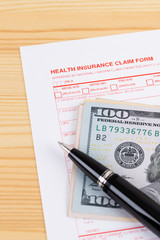 Health insurance claim form with pen on wooden desk