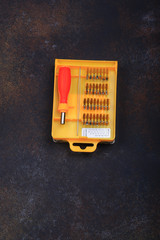 screwdriver with a set of nozzles on a vintage background