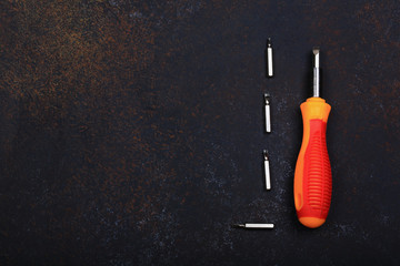 screwdriver with a set of nozzles on a vintage background