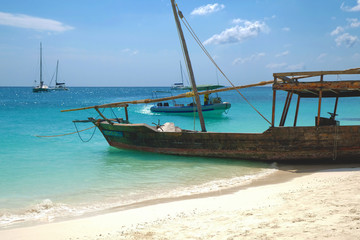 Wooden traditional ship on paradise sandy beach of Zanzibar island Indian ocean