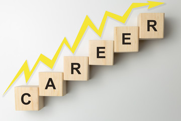 Wooden blocks arranged in stair shape with the word CAREER. Arrow pointing up