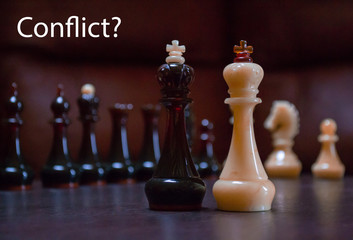 Black and white chess pieces with Conflict word