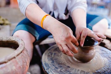 Woman moulding clay on pottery wheel