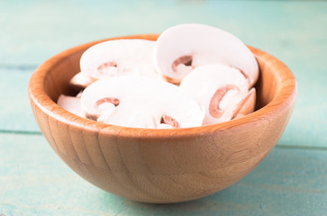 Sliced raw white champignons preparing for cooking