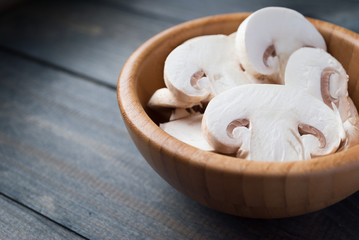 Sliced raw white champignons preparing for cooking