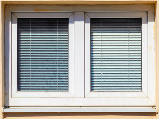 Closed Window Blinds on a Sunny Day View from the Street. Sun Protection in Architecture Concept. Copy Space