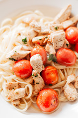 Grilled lean chicken strips with fresh herbs and pepper and sautéed and glazed cherry tomatoes on Italian Linguine or Fettuccine pasta topped with grated parmesan cheese, healthy, low calorie dish