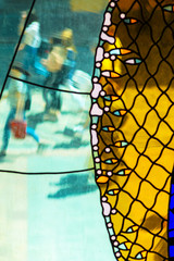 Colorful Stained-Glass Window. Abstract Multicolored Background. Blured Figures of People Walking Down the Street Behind Glass