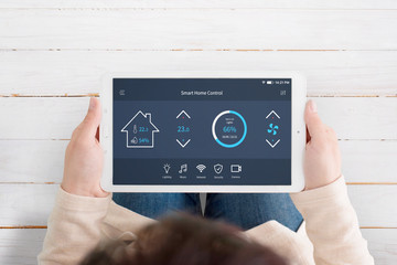 Modern, automated home control app with artificial intelligence on tablet display in woman hands....