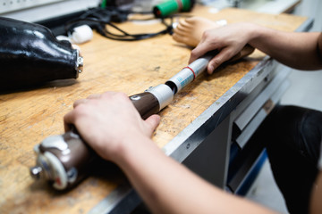 Disabled man working in amputee shop for production prosthetic extremity parts.