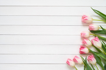 Pink tulips bouquet on white wooden background. Top view, copy space. Greeting card.