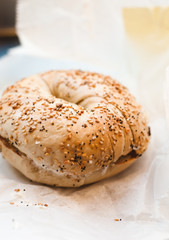 Freshly baked Bagel with sesame, poppyseed topping and cream cheese spread and lox from coffee shop, cafe or bakery in Williamsburg, Brooklyn, New York City, close up with selective focus