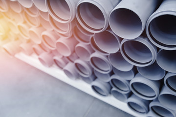 PVC plastic construction pipes for water are displayed in row on counter